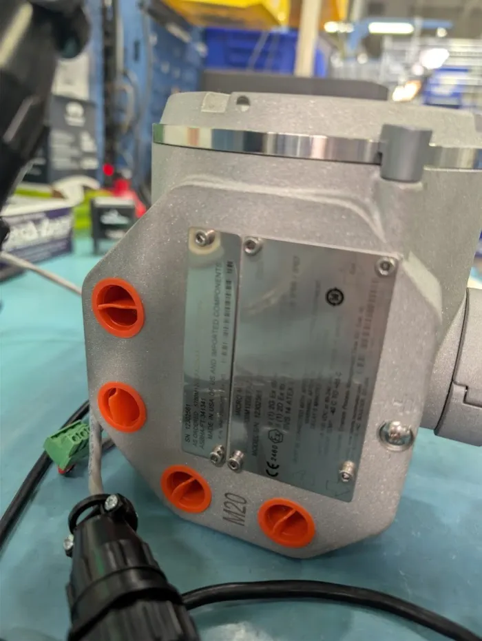 Close-up of a Micro Motion transmitter housing with ATEX and IECEx nameplate markings being verified during inspection