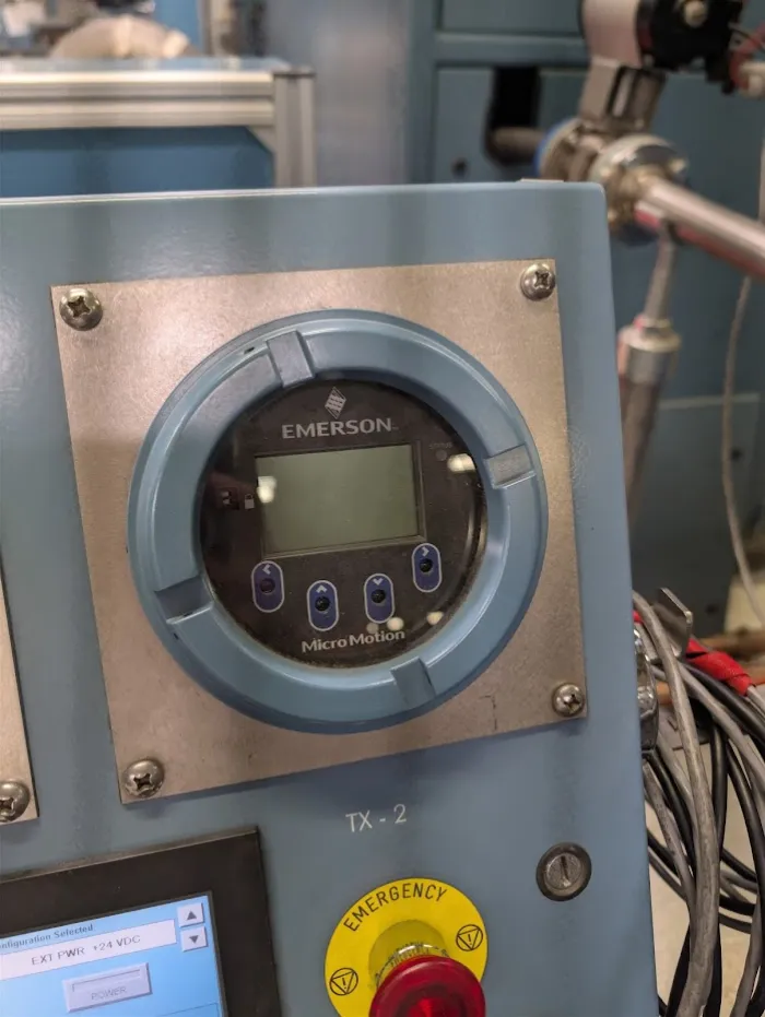 Emerson Micro Motion transmitter display mounted on a test panel during a configuration and functional test